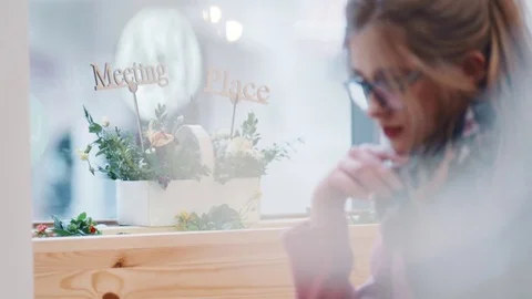 Blurred view of a young pretty lady in casual wear, relaxing in the café  Stock Footage 74254078