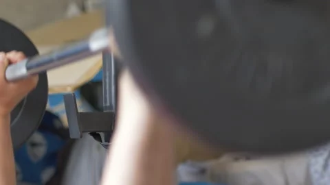 Blurred weights and focus on rack during bench press fitness exercise. homegym Stock Footage 142140191