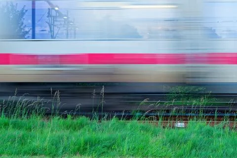 Blurred white Deutsche Bahn train speeding past green grass Stock Photos
