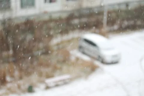 Blurred winter background with snowflakes on the foreground Stock Photos