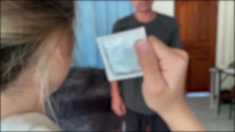 Blurred young asian couple arguing in room. Wife throw condom pack at husband Stock Footage 230095028