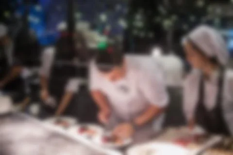 Blurry background of Chef in hotel or restaurant kitchen cooking and decorati Stock Photos