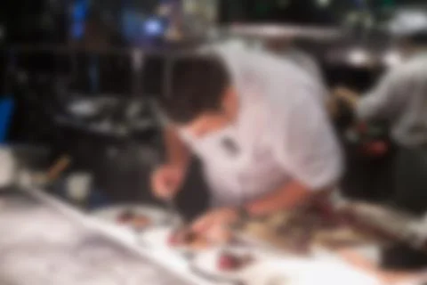 Blurry background of Chef in hotel or restaurant kitchen cooking and decorati Stock Photos