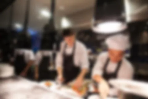 Blurry background of Chef in hotel or restaurant kitchen cooking and decorati Stock Photos
