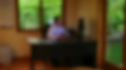 Blurry Background of man working remotely at desktop computer Stock Footage 333706895