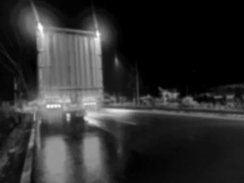 A blurry black and white image of a truck at night Stock Photos