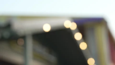 Blurry bokeh background of outdoor cafe roofs decorated with warm lights. Stock Footage 341136323