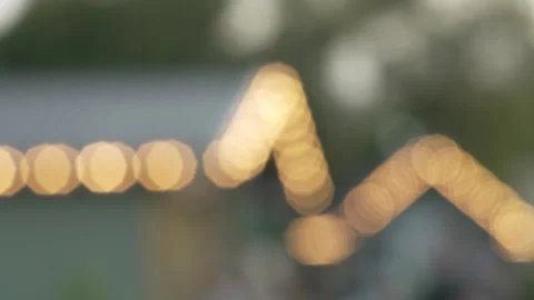 Blurry bokeh background of outdoor cafe roofs decorated with warm lights. Stock Footage 341136595