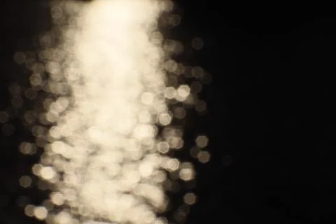 Blurry bokeh of sunset reflection in surface of lake as background Stock Photos