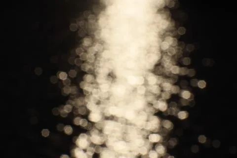 Blurry bokeh of sunset reflection in surface of lake as background Stock Photos