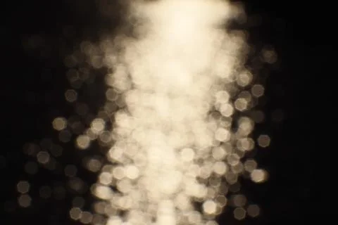 Blurry bokeh of sunset reflection in surface of lake as background Stock Photos