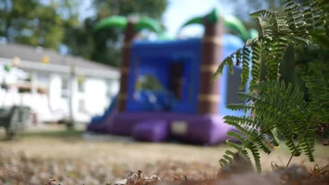 A Blurry Bounce House in Backyard Birthday Party Stock Footage 317522969