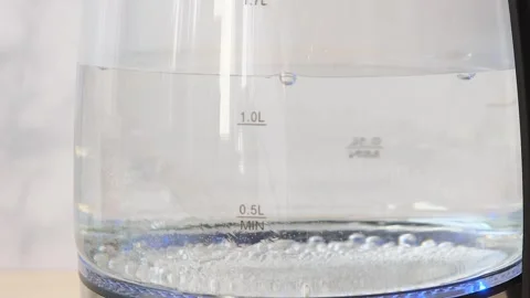 Blurry bubbles in hot water boiling inside glass teapot . Close-up of boiling wa Stock Footage 282654730