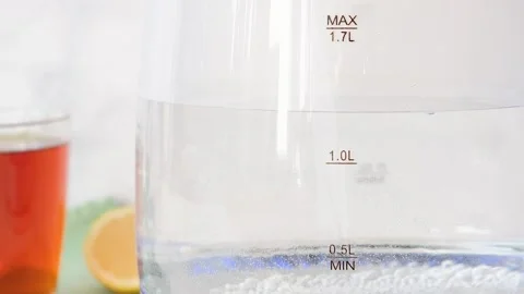 Blurry bubbles in hot water boiling inside glass teapot . Close-up of boiling wa Stock Footage 282654734
