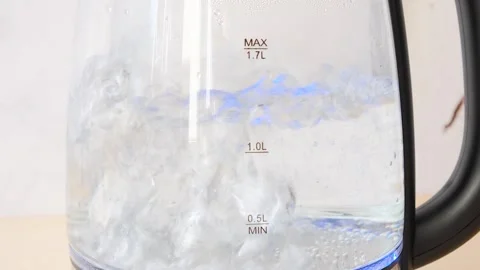 Blurry bubbles in hot water boiling inside glass teapot . Close-up of boiling wa Stock Footage 282655128