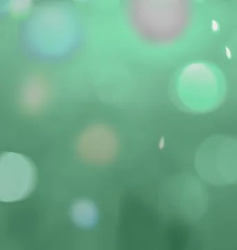 Blurry circles of light, colored balls, glowing drops on a green background Stock Illustration