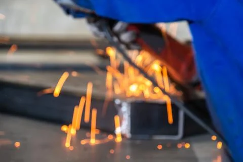 Blurry construction concept background of worker using angle grinder on Stock Photos