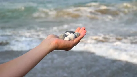 Blurry defocus Beautiful round gray and white sea stones lie in a female hand 库存影片 134745005