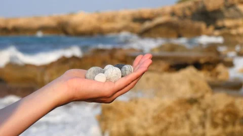 Blurry defocus Beautiful round gray and white sea stones lie in a female hand 库存影片 134804155
