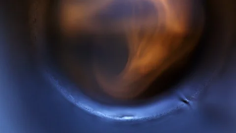 A blurry fire bruning behind a blue lit weld seam Stock Footage 120204802