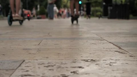 Blurry ground-level slow-motion shot of two kids strolling on the city sidewalk Vidéo 278827020