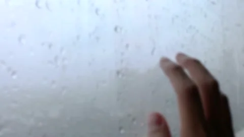 Blurry hand on window with raining outside Stock Footage 133022552