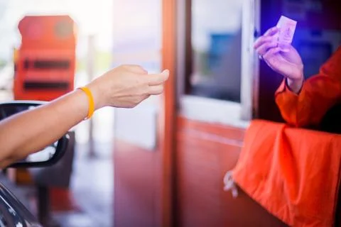 Blurry hands of driver pay for the expressway. Stock Photos