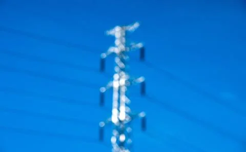 Blurry high voltage post or power transmission line tower and blue sky Stock Photos