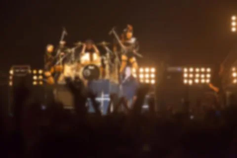 Blurry image background of musicians rock in big rock concert. Stock Photos