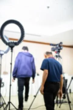 Blurry image of cameramans working with camera and blurry ring lighting in .. Stock Photos