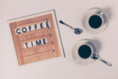A blurry image of coffee cups with text on the board. Stock Photos
