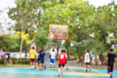 Blurry image of elderly men and teens playing basketball in the morning at Ba Stock Photos