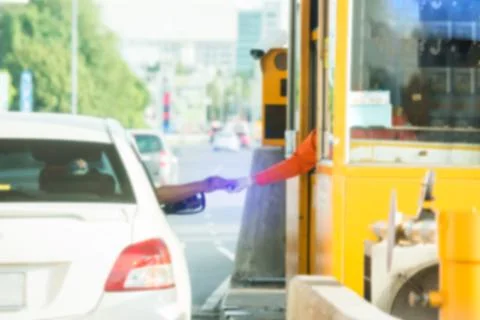 Blurry image of hand of driver pay for the expressway. Driver pays money to a Stockfoto's
