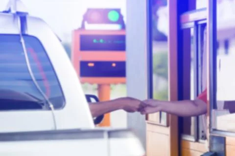 Blurry image of hand of driver pay for the expressway. Driver pays money to a Stockfoto's