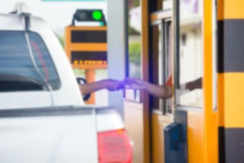 Blurry image of hand of driver pay for the expressway. Driver pays money to a Stockfoto's