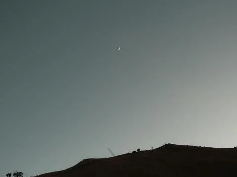 A blurry image of a hill with a large, glowing moon in the sky Stock Photos