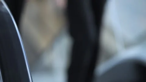 Blurry image of a person with a brown jacket and a black car Stock Footage 310838878