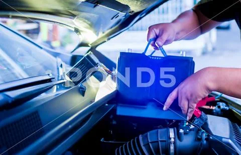 Blurry of male mechanic changing car battery, mechanic engineer fixing car ba Stock Photos