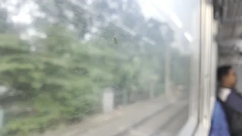 Blurry Passenger looking out window of a moving train on a cloudy day. 動画素材 344102347
