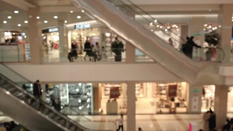 Blurry people moving on escalators inside bustling shopping mall. Stock Footage 319023841