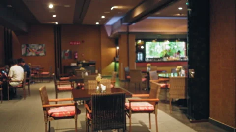 Blurry scene in a cozy restaurant with bokeh lights, defocused tables, and .. Stock Footage 307404111