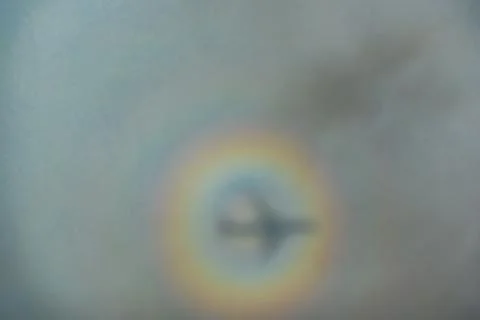 Blurry shadow of the airplane on the cloud with the rainbow circle. traveling Stock Photos