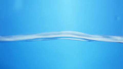 Blurry shot of dancing waves of water inside a container in a blue Stock Footage 285522374