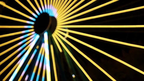 Blurry spiraling yellow and blue light show on ferris wheel Stock Footage 124305960