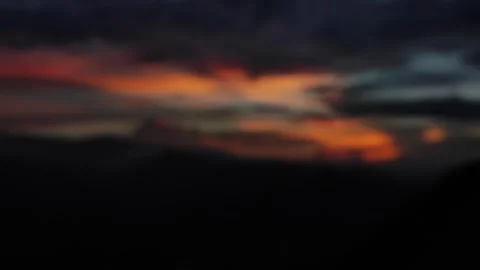 Blurry sunset sky with orange clouds and dark moody atmosphere, a dreamy Stock Footage 345072279