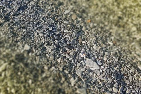 A blurry tilt-shift pattern of polished stones in a rocky beach Stock Photos