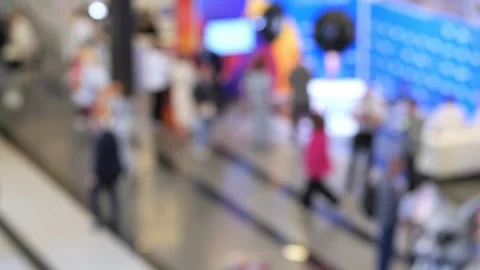 Blurry view of shoppers in modern mall with escalators and store fronts Stock Footage 344994946