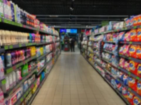 Blurry view of a spacious retail area with long shelves of merchandise for .. Stock Photos