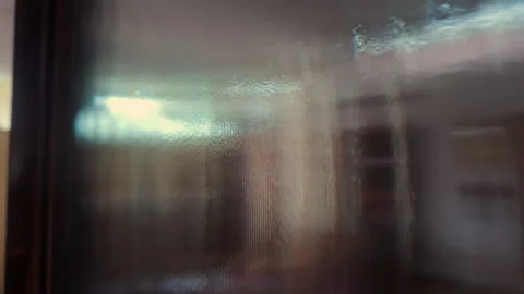 Blurry view through frosted textured glass surface showing distorted shapes.. Stock Footage 314607448