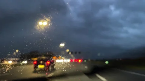 Blurry, wipers are wiping the windshield at night, traffic in rain Video stock 255227059